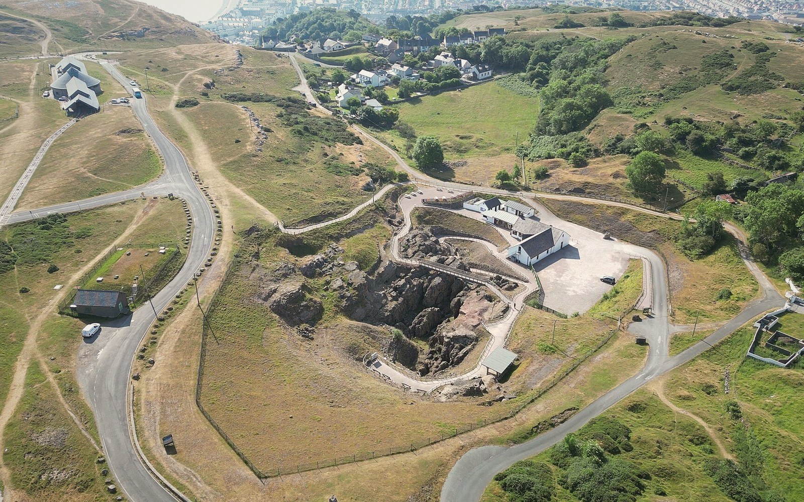 Aerial view of Great Orme's exposed copper mine spoil surrounded by hillside roads and buildings